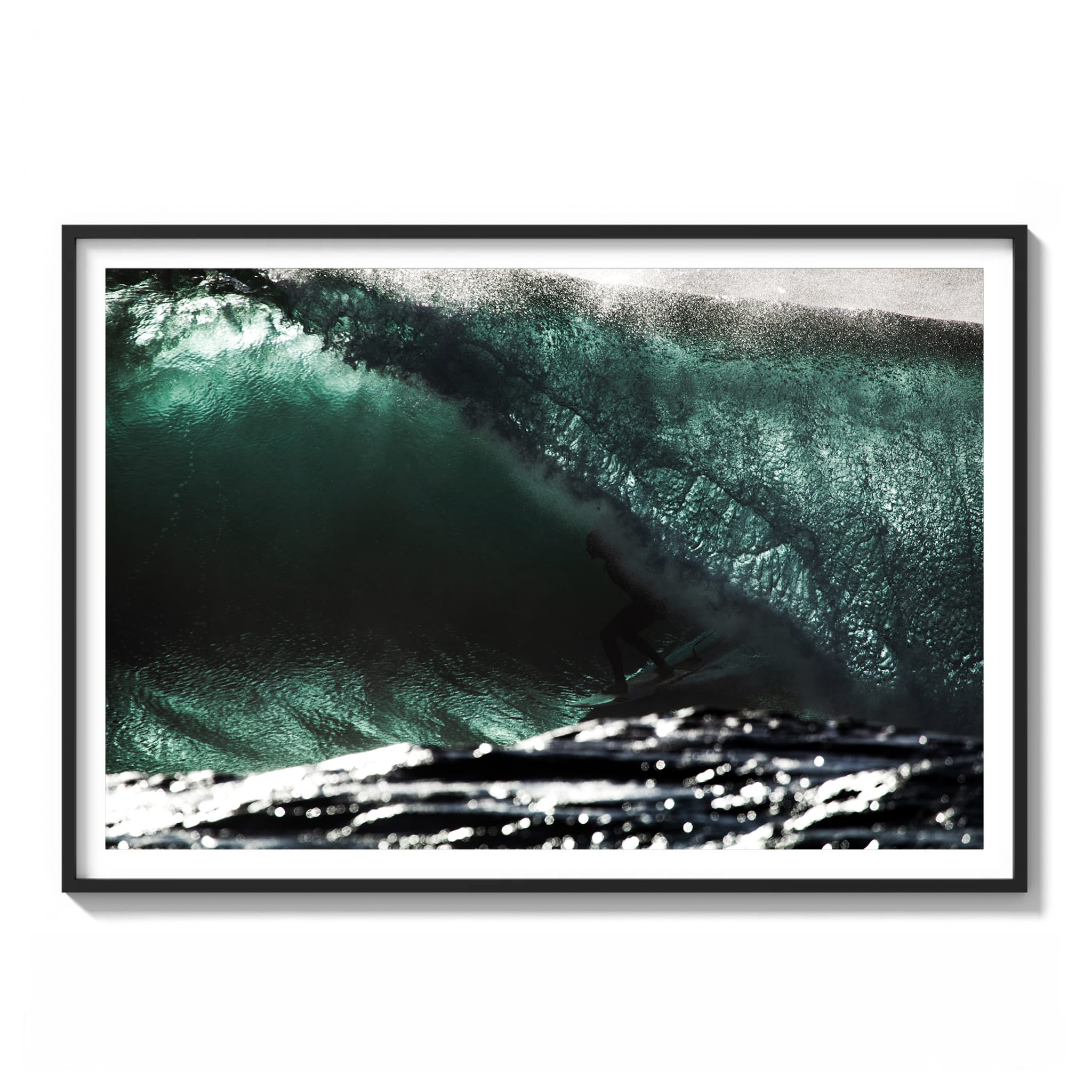 Color photograph of a surfer riding low inside a glassy green wave, sunlight fracturing through the barrel framed.