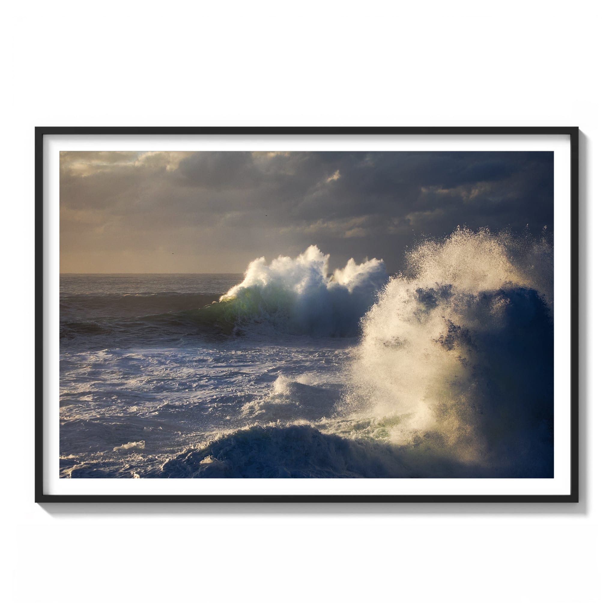 Color photograph of a large breaking wave with green translucent light under stormy skies on the east coast of Australia framed.