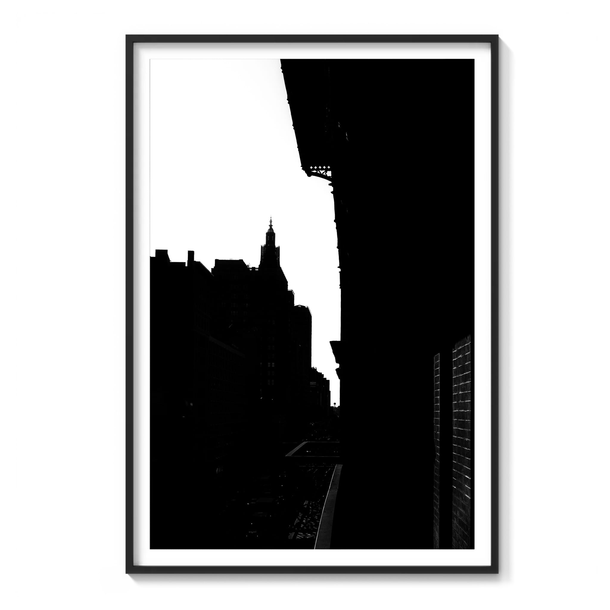Framed black and white photograph of a building silhouette and fire escape against the Manhattan skyline near the Chelsea Hotel, New York City.