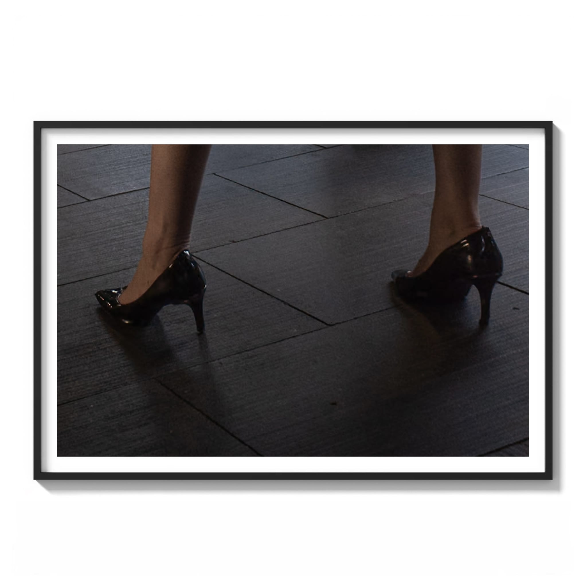 Framed color photograph of a person's feet in black heels walking on textured pavement in downtown Sydney.