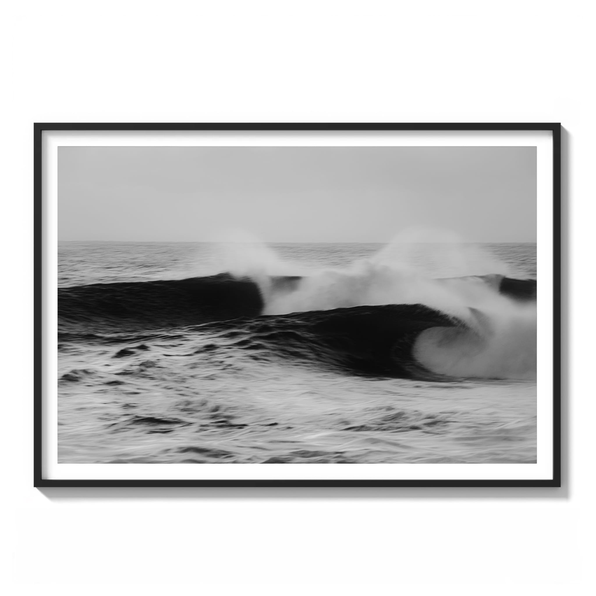 Black and white long-exposure photograph of two wave faces off the Sydney coast with soft, misty spray framed.