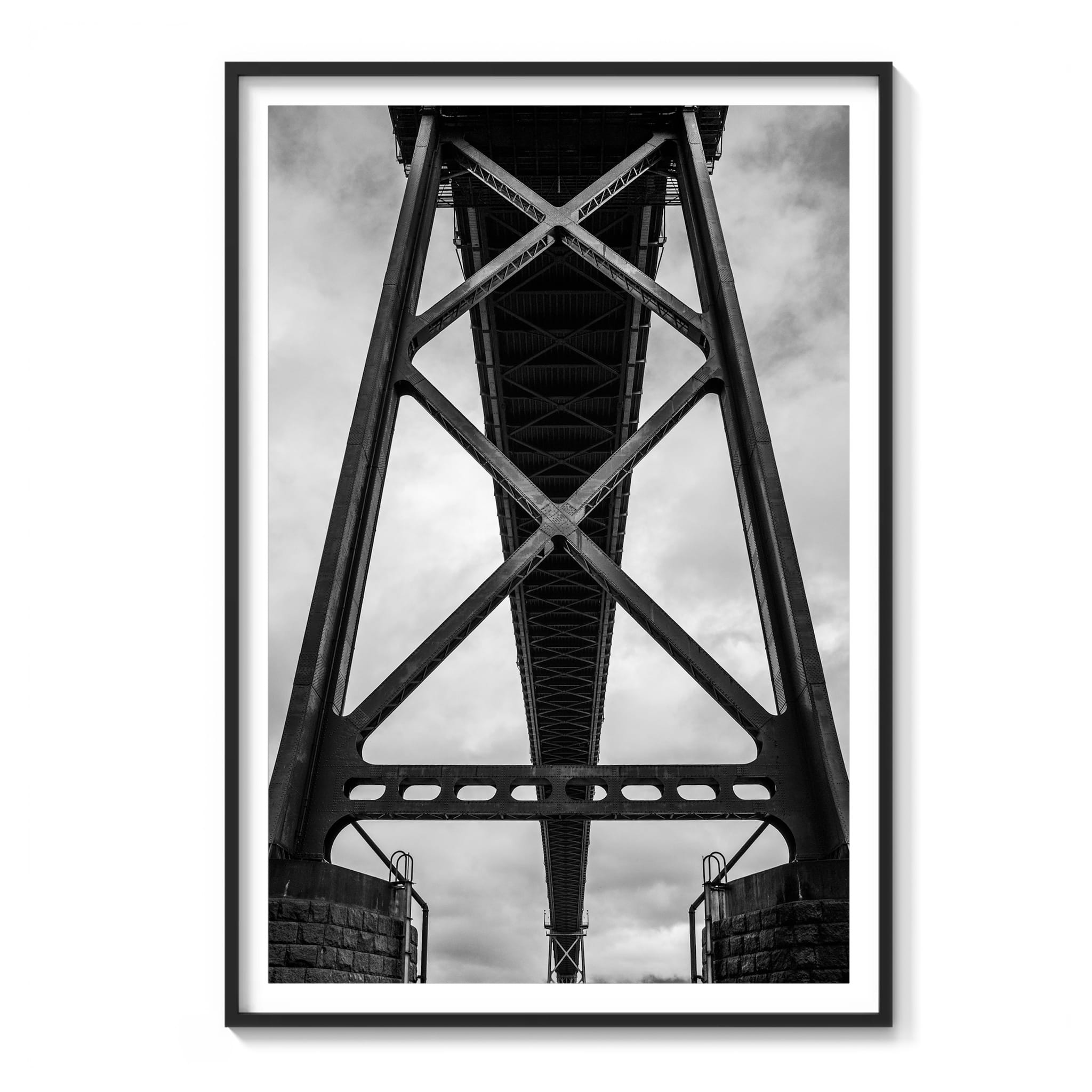 Framed black and white photograph of a symmetrical steel bridge truss structure viewed from directly below in Vancouver.