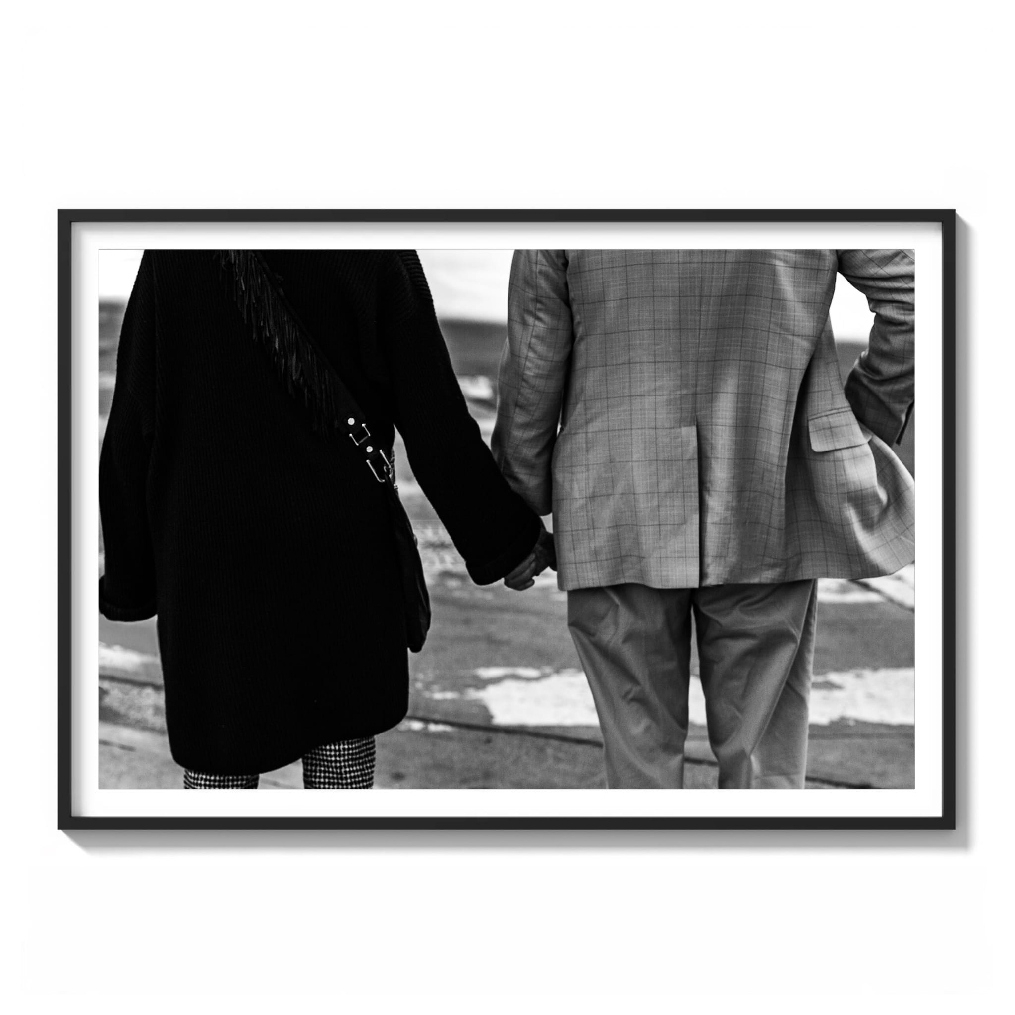 framed black and white photograph of a couple holding hands from behind, looking out toward water in downtown Los Angeles.