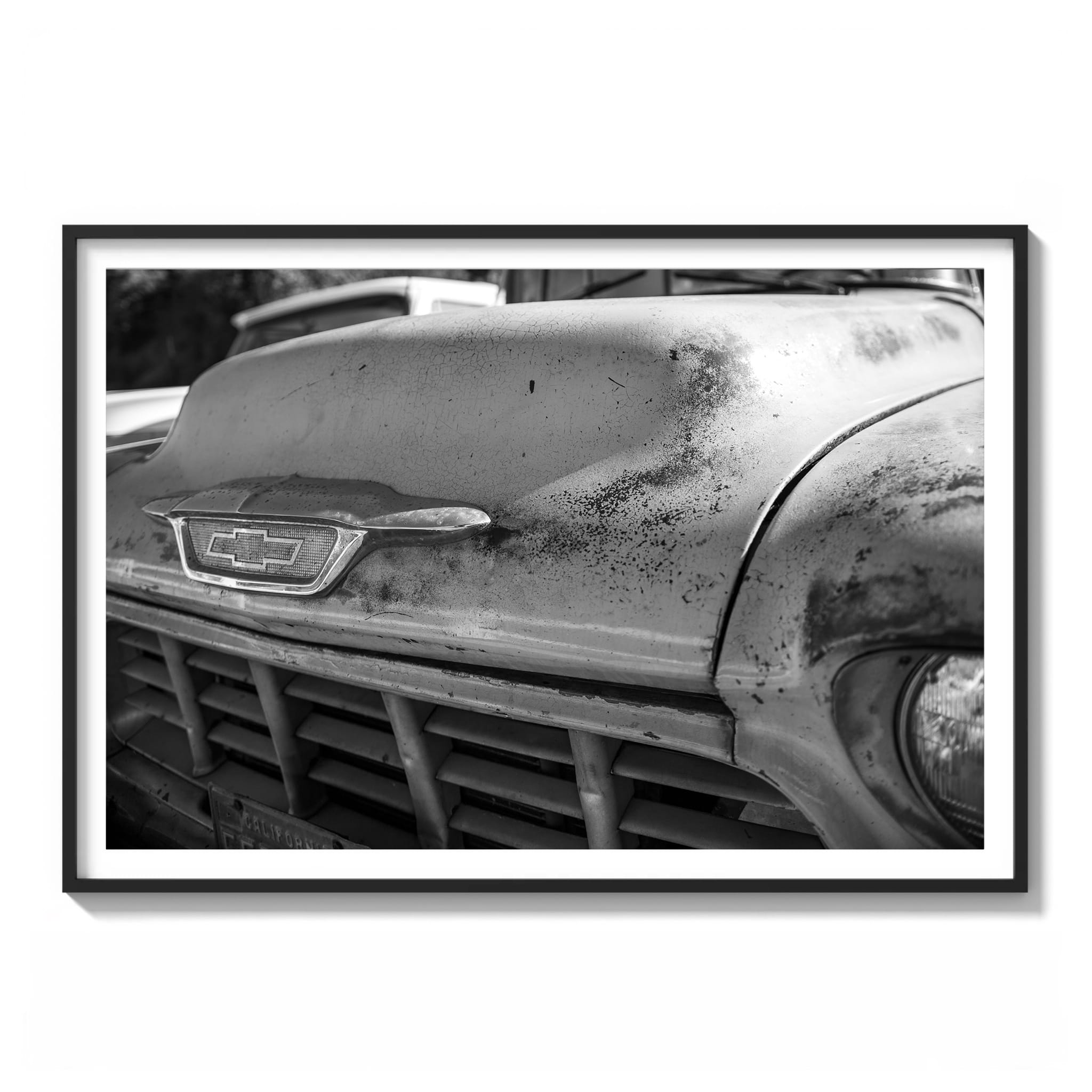 Framed black and white close-up photograph of a weathered vintage Chevrolet truck hood with cracked paint and rust patina in Los Angeles.